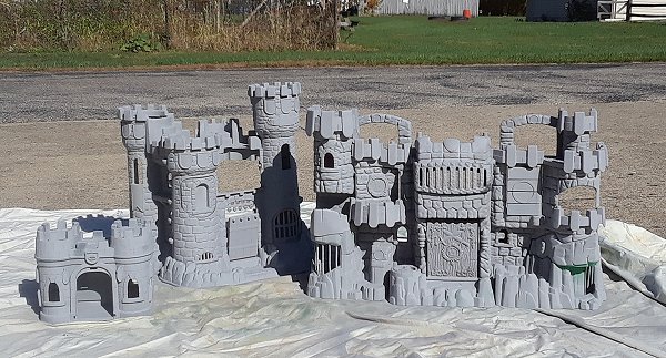 Three thrift-shopped Fisher Price castles primed with multiple coats of gray primer. Click for bigger photo.