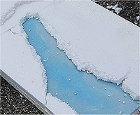 The lucite ice river takes shape as borders are glued around it and edges are smoothed off.