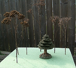 In this photo, the yarrow is on the left; the other twigs are from Autumn Joy sedum. The resin tree helped hold the floral block down so I could photograph it when the wind gusted. Click for bigger photo.